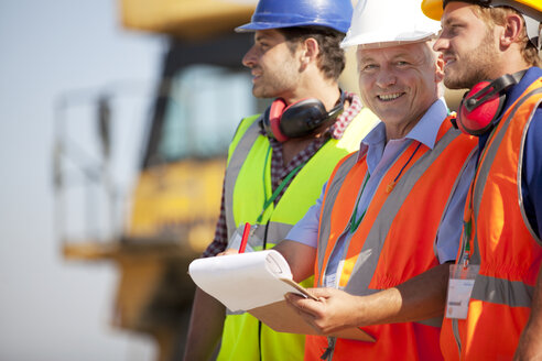 Businessman and workers talking on site - CAIF01402