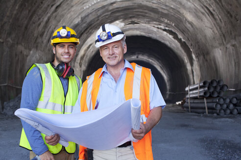 Workers reading blueprints in tunnel - CAIF01429