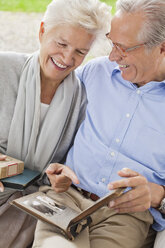 Couple looking through photo album together - CAIF01450