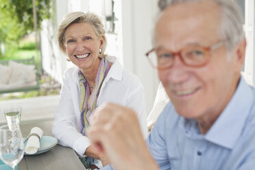 Couple smiling together at table - CAIF01484