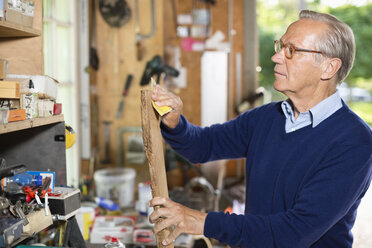 Man sanding wood in garage - CAIF01486