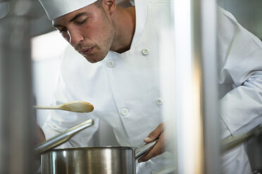 Chef tasting food in restaurant kitchen - CAIF01490