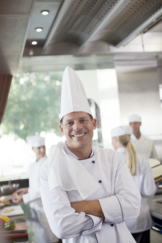 Chefkoch lächelt in der Restaurantküche, lizenzfreies Stockfoto