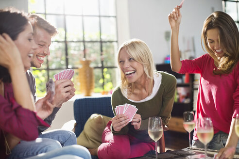 Freunde spielen Kartenspiel im Wohnzimmer - CAIF01520