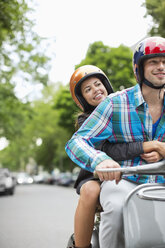 Couple riding scooter together - CAIF01528