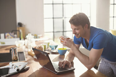 Mann mit Laptop und einer Tasse Kaffee - CAIF01562