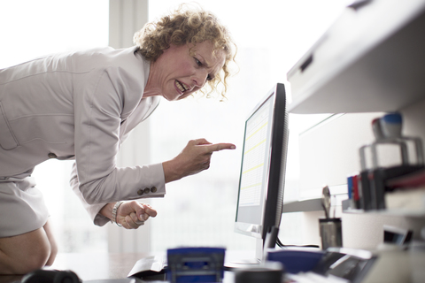 Geschäftsfrau schreit am Computer im Büro, lizenzfreies Stockfoto