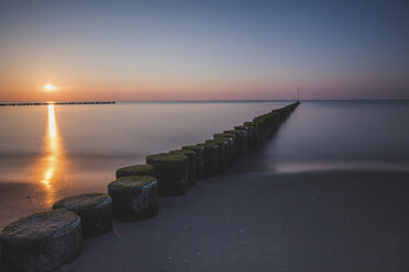 Deutschland, Mecklenburg-Vorpommern, Wustrow, Ostsee, Wellenbrecher bei Sonnenuntergang im Winter - ASCF00823