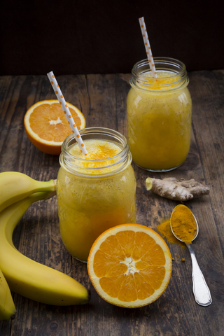 Orangen-Bananen-Smoothie mit Ingwer und Kurkuma, lizenzfreies Stockfoto