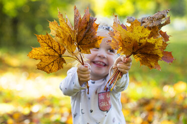 Glückliches kleines Mädchen mit herbstlichen Blättern - WWF04197