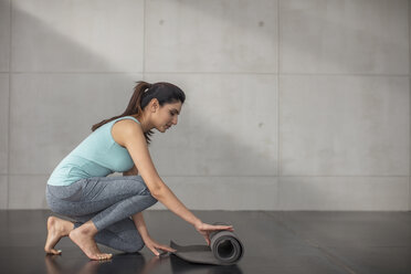 Junge Frau bereitet sich auf Yoga-Übungen im Studio vor - ZEF15094