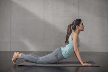 Young woman doing yoga exercise in studio - ZEF15097