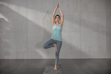 Young woman doing yoga exercise in studio - ZEF15098