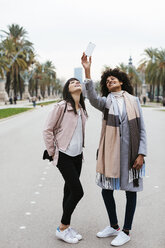 Spanien, Barcelona, zwei glückliche Frauen machen ein Selfie auf der Promenade - EBSF02149