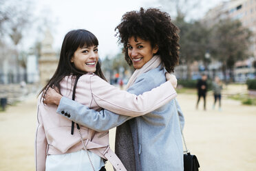 Spain, Barcelona, portrait of two happy women in city park embracing turning round - EBSF02180