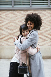 Spain, Barcelona, two happy women embracing in the city - EBSF02187