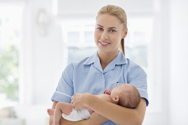 Nurse holding newborn baby in hospital - CAIF01884