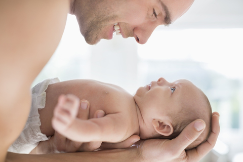 Vater wiegt neugeborenes Baby, lizenzfreies Stockfoto
