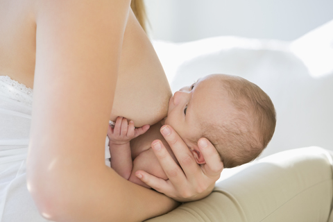 Mutter, die ihr neugeborenes Kind stillt, lizenzfreies Stockfoto