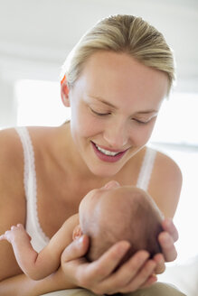 Mutter wiegt neugeborenes Baby - CAIF01907
