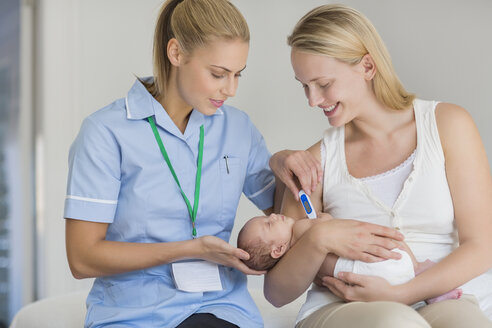 Mutter und Krankenschwester messen die Temperatur des Neugeborenen - CAIF01909