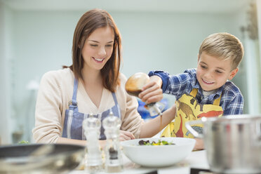 Mutter und Sohn machen Salat in der Küche - CAIF01919