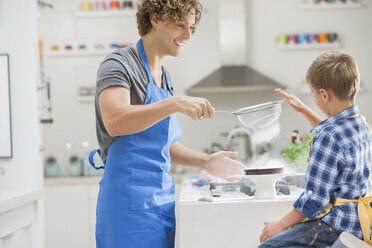 Father and son baking in kitchen - CAIF01935