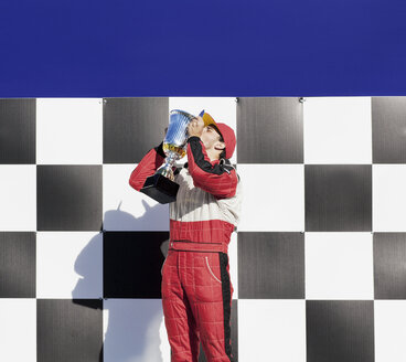 Rennfahrer küsst Trophäe bei der Preisverleihung - CAIF01979