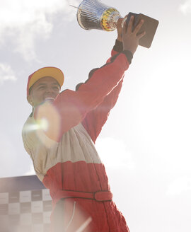 Rennfahrer mit Trophäe bei der Preisverleihung - CAIF01983