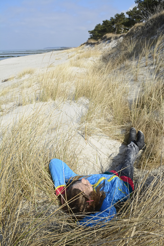 Deutschland, Hiddensee, Mädchen entspannt in den Dünen, lizenzfreies Stockfoto