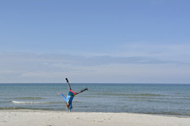 Deutschland, Pommern, Hiddensee, Mädchen macht Handstand am Strand - BFRF01823