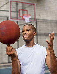 Mann dreht Basketball auf Finger - CAIF02031