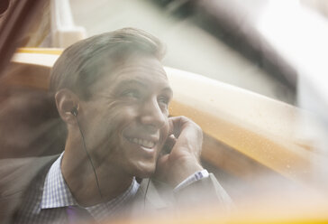 Geschäftsmann, der im Taxi mit seinem Handy telefoniert - CAIF02043