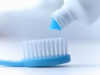 Close up of toothpaste squeezing on toothbrush - CAIF02080