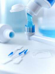 Nahaufnahme von Zahnpasta, die auf eine elektrische Zahnbürste gepresst wird - CAIF02085