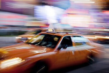 Blurred view of taxi on city street at night - CAIF02115