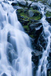 Waterfall rushing over rocky hillside - CAIF02138
