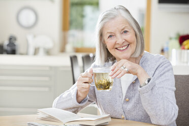 Ältere Frau trinkt Tee und liest - CAIF02181