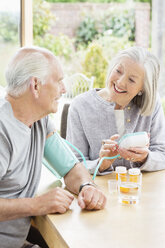 Ältere Frau testet den Blutdruck ihres Mannes - CAIF02183
