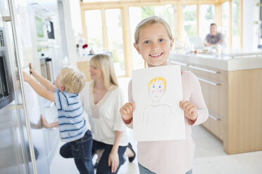 Mädchen zeigt ihre Zeichnung in der Küche - CAIF02185