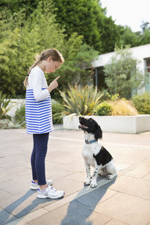 Mädchen schimpft mit Hund im Freien - CAIF02205