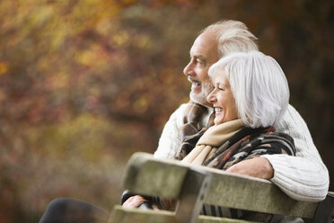 Older couple sitting on park bench - CAIF02285