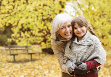 Ältere Frau und Enkelin lächelnd im Park - CAIF02303