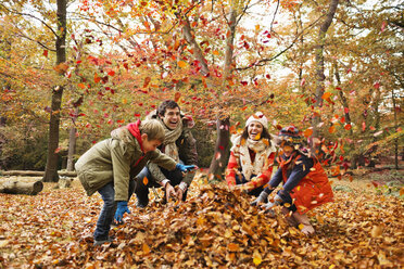 Family playing in autumn leaves - CAIF02311