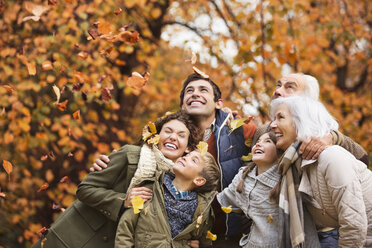 Familie spielt im Herbst Blätter im Park - CAIF02328