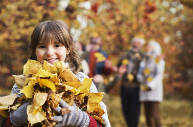 Girl playing with autumn leaves in park - CAIF02355