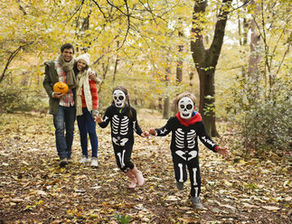 Children in skeleton costumes playing in park - CAIF02356