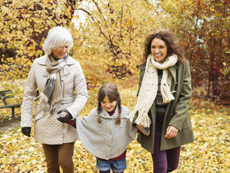 Drei Generationen von Frauen gehen im Park spazieren - CAIF02360