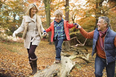 Family walking on log in park - CAIF02361