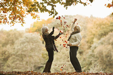 Älteres Paar spielt im Herbstlaub - CAIF02375
